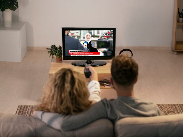 Casal assistindo TV na sala